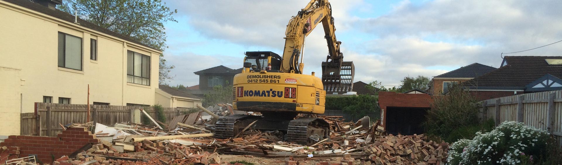backhoe at house demolition site
